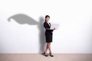 Superhero business woman using laptop computer with white wall background, great for your design or text, asian